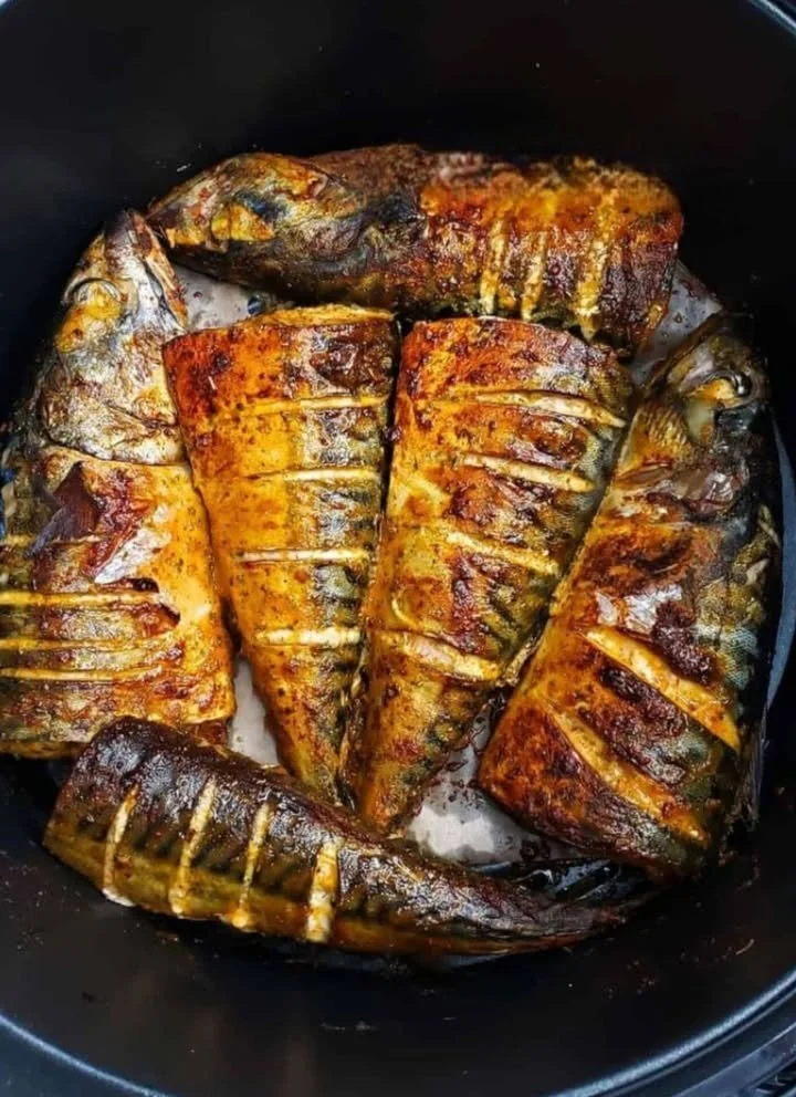 Delicious air fryer mackerel recipe served on a plate with lemon wedges.