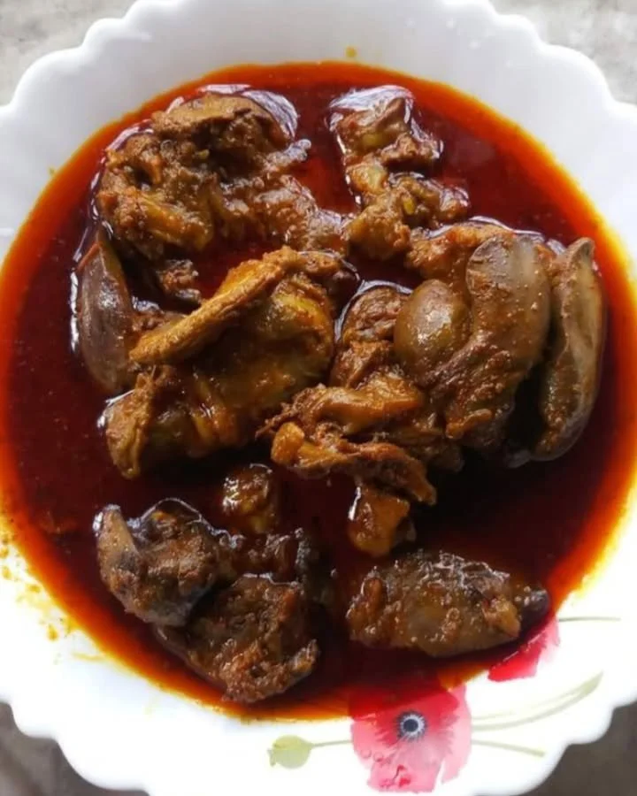 Delicious bowl of chicken liver curry garnished with fresh herbs.