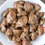 Deliciously cooked chicken liver fry served on a plate with herbs.