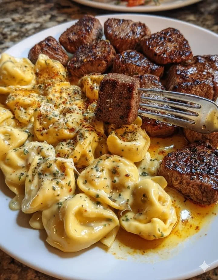 Delicious Garlic Butter Steak Tips served with penne in creamy Parmesan Velveeta sauce