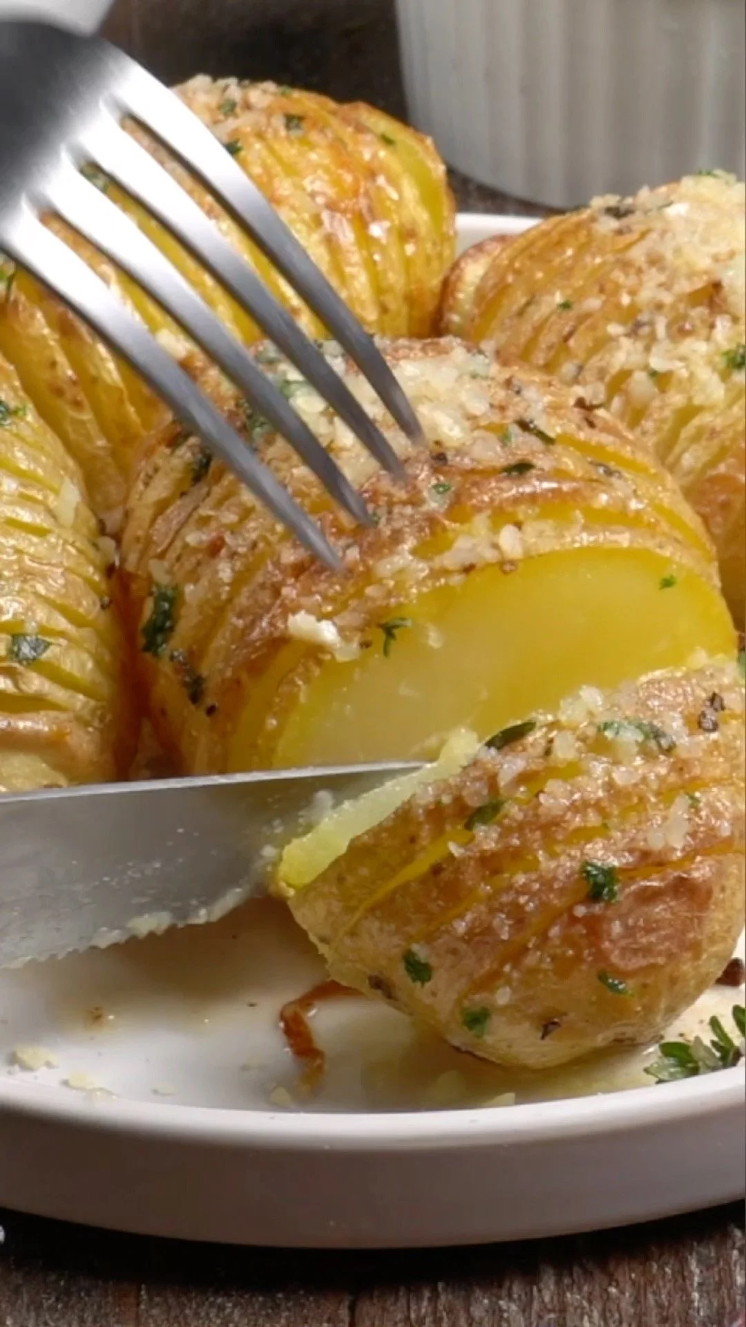Deliciously crispy Hasselback Potatoes garnished with herbs