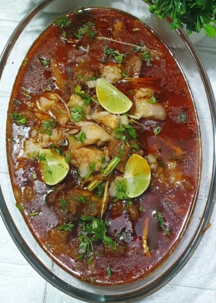 Delicious plate of Mutton Nihari served with naan and garnished with fresh herbs