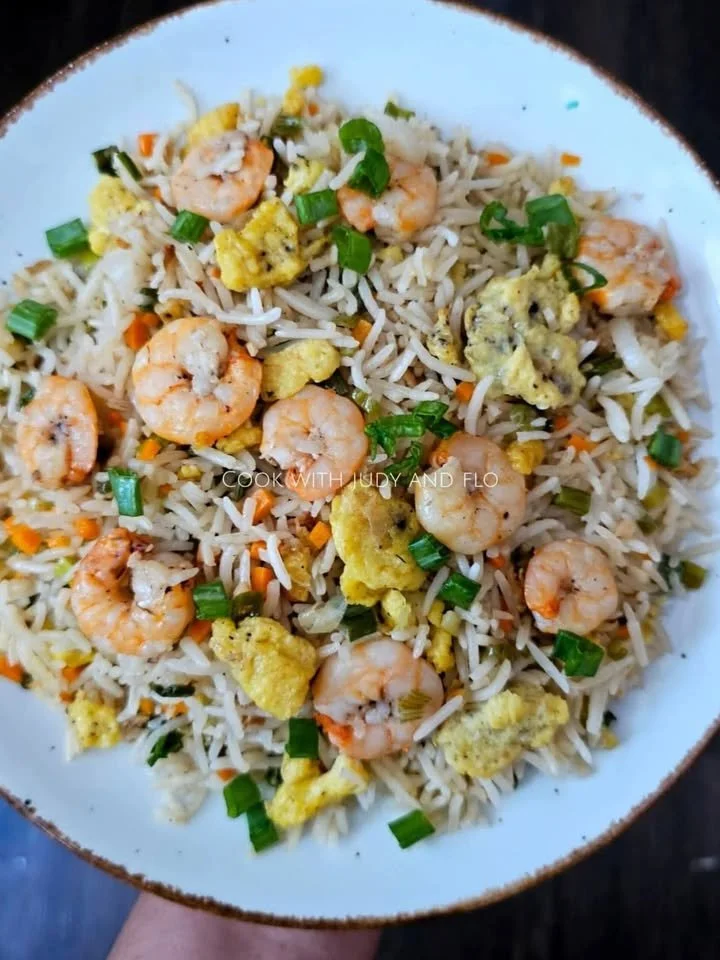 Delicious plate of prawn fried rice garnished with vegetables and herbs