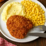 home Delicious Southern oven-fried chicken served on a plate with sides.