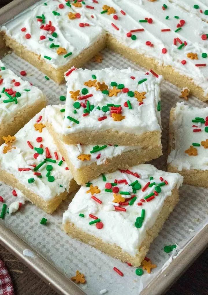 Delicious homemade sugar cookie bars topped with frosting and sprinkles.