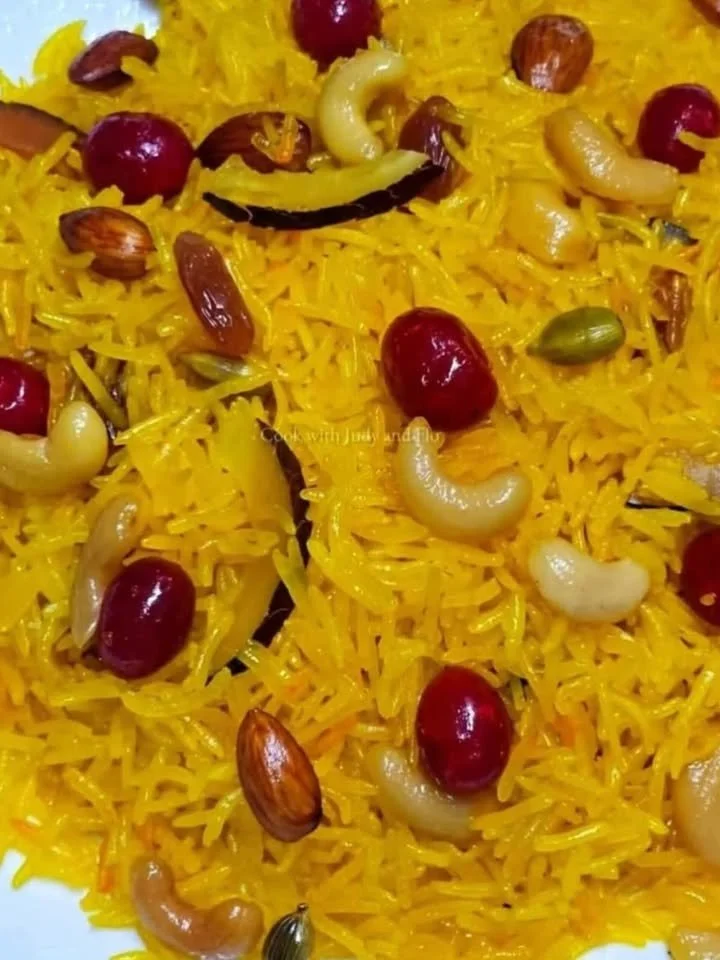 A colorful bowl of Zarda, a sweet rice dessert with nuts and spices.