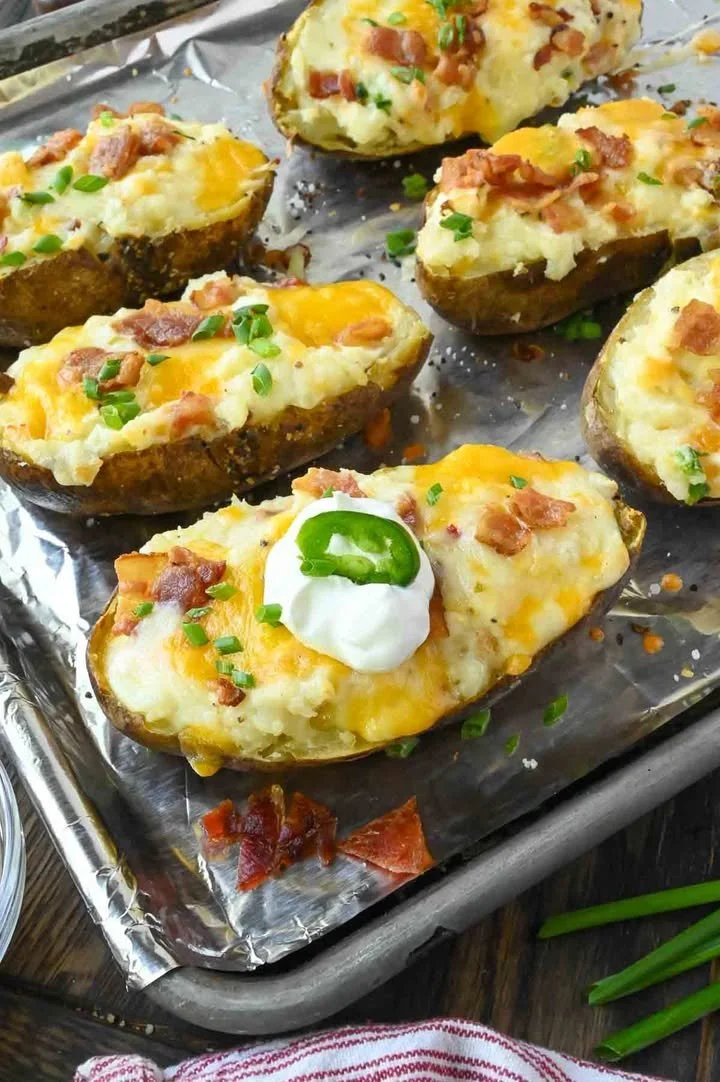 Creamy cheesy mashed potato skins topped with gooey cheese and herbs