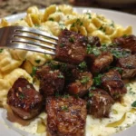 home Creamy garlic Parmesan shells served with tender steak bites on a plate