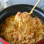 home A bowl of delicious crockpot chicken spaghetti with tomatoes and cheese.