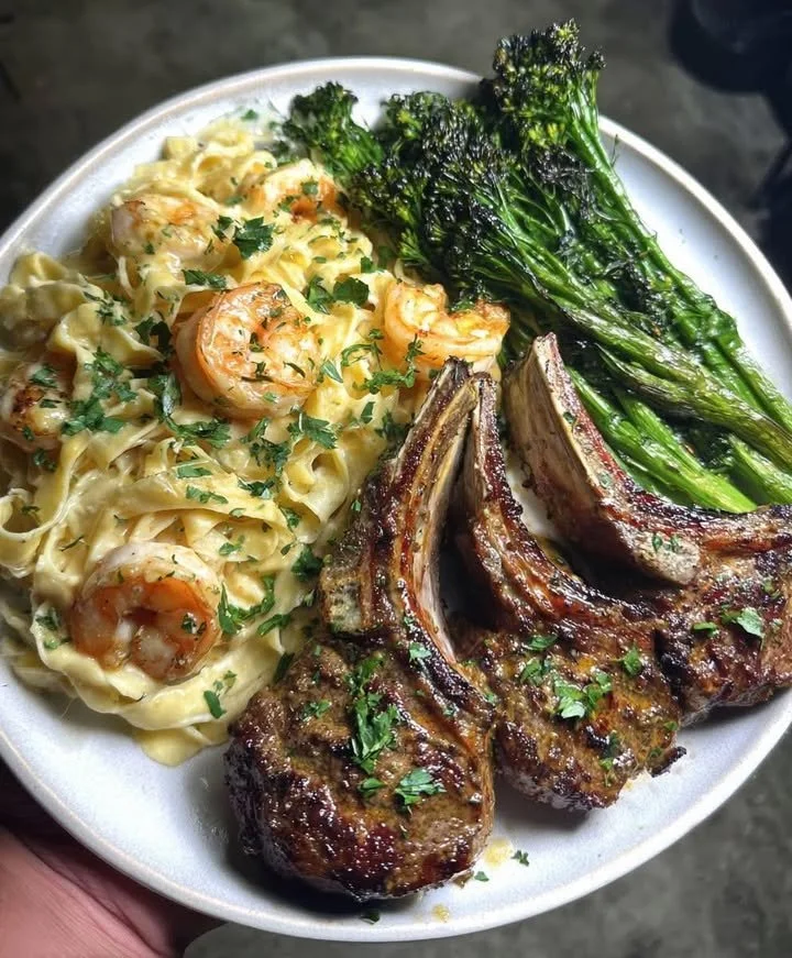 Plate of Garlic Lamb Chops served with Shrimp Alfredo and Roasted Broccolini
