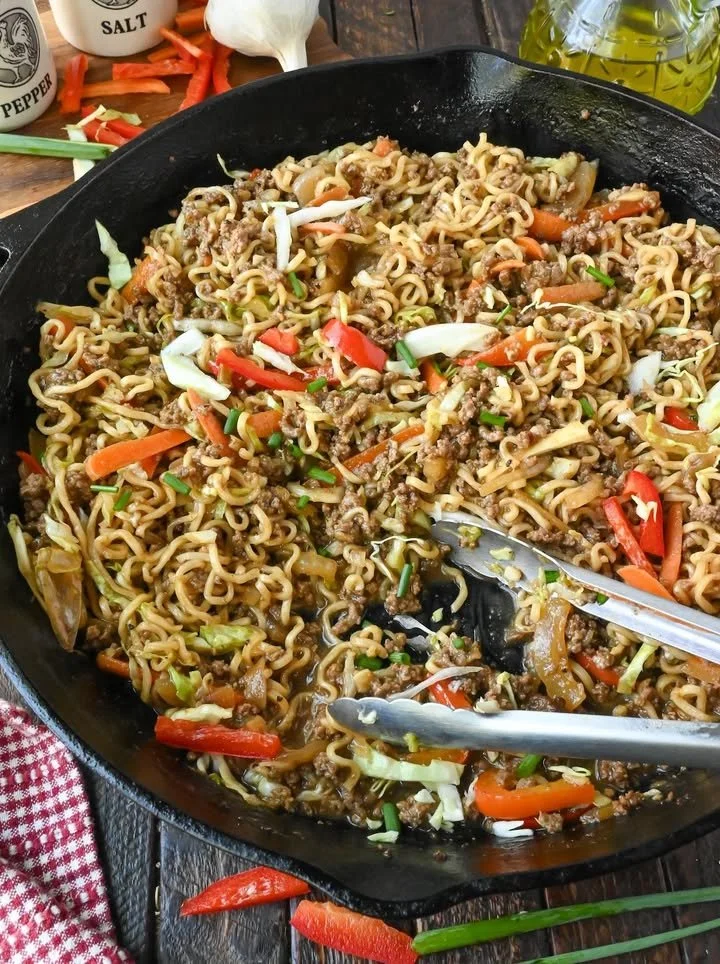 Plate of delicious ground beef and ramen noodles dish garnished with green onions.