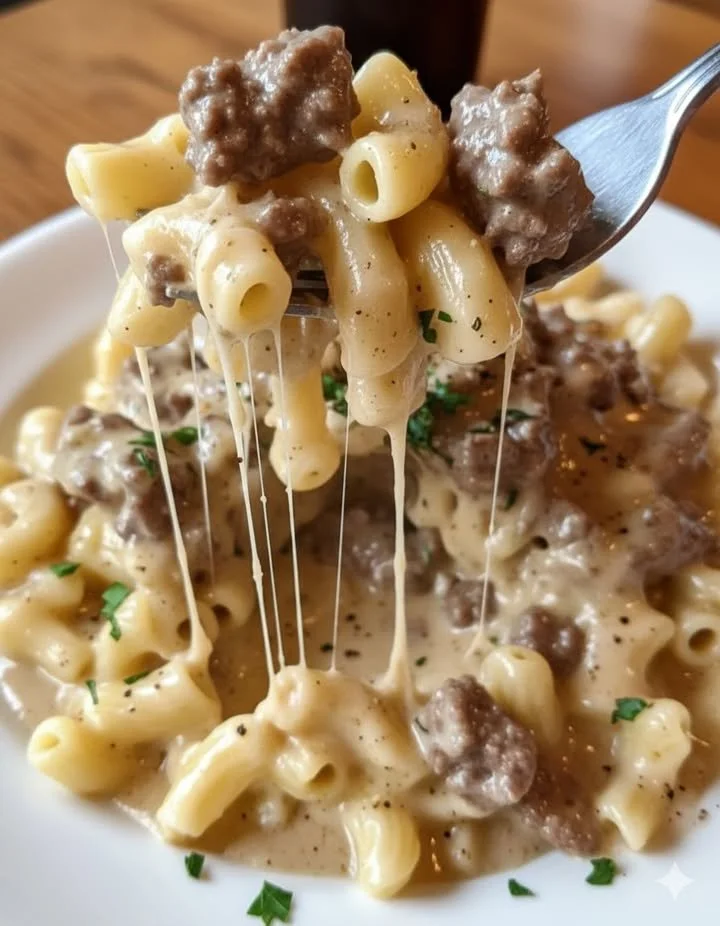 Plate of rich Garlic Parmesan Beef with elbow macaroni and garnished with parsley