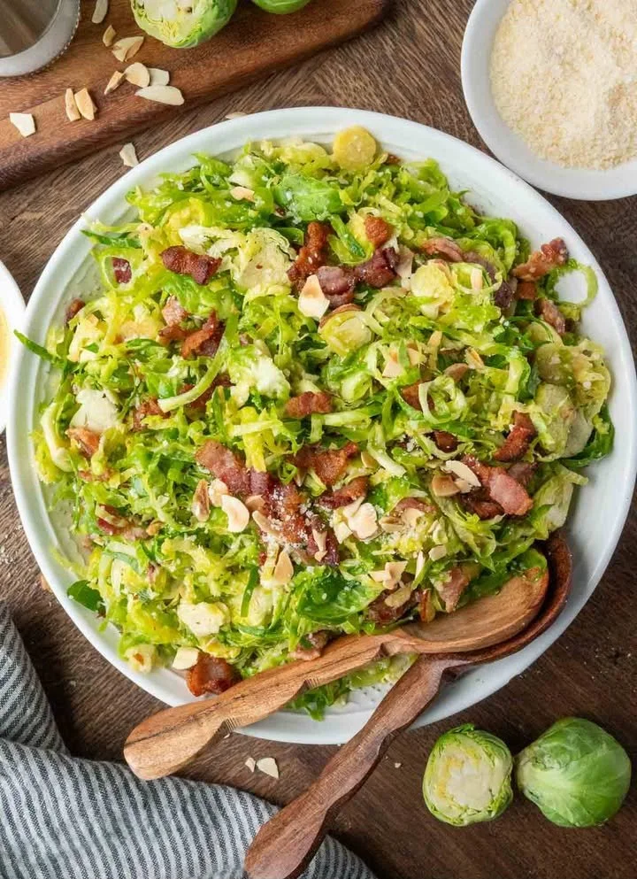 Fresh Shaved Brussels Sprouts Salad garnished with nuts and dressing