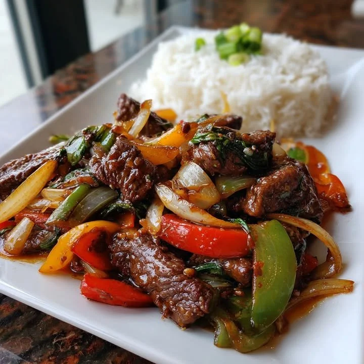Delicious sizzling Chinese pepper steak with onions served in a bowl.