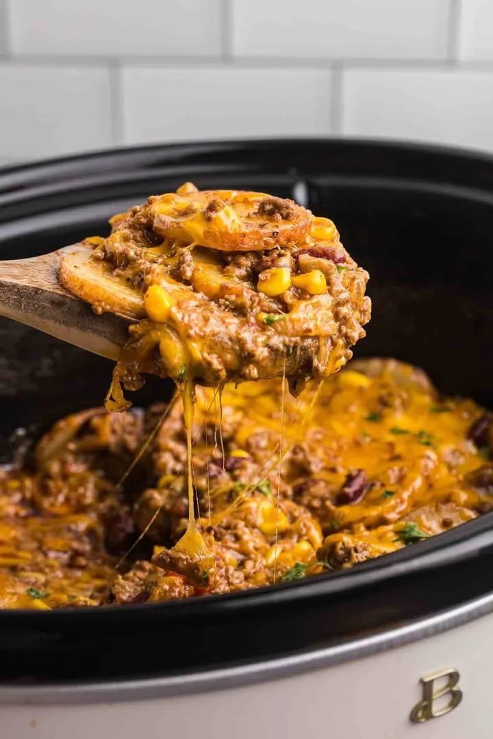 Plate of slow cooker cowboy casserole with ingredients and toppings