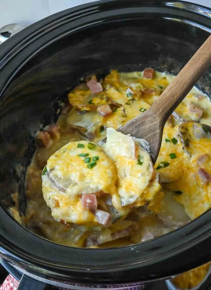 Slow Cooker Creamy Ham and Potatoes Bowl of slow cooker creamy ham and potatoes with herbs and cheese