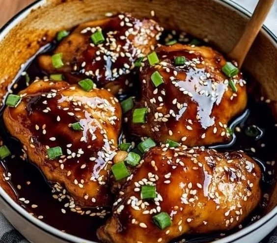 Juicy oven-baked teriyaki chicken garnished with sesame seeds and green onions