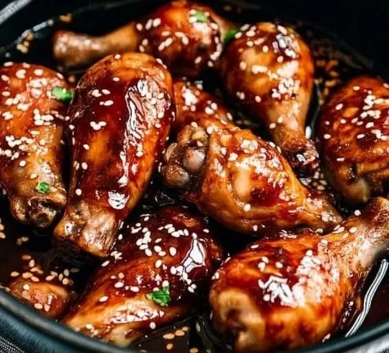 Slow cooker Asian glazed chicken drumsticks on a plate with garnishes